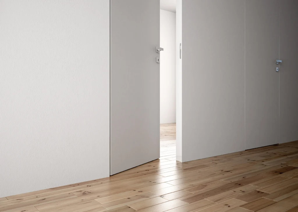 Unsichtbare wandbündige weiße Tür ohne sichtbare Zarge im minimalistischen Wohnraum