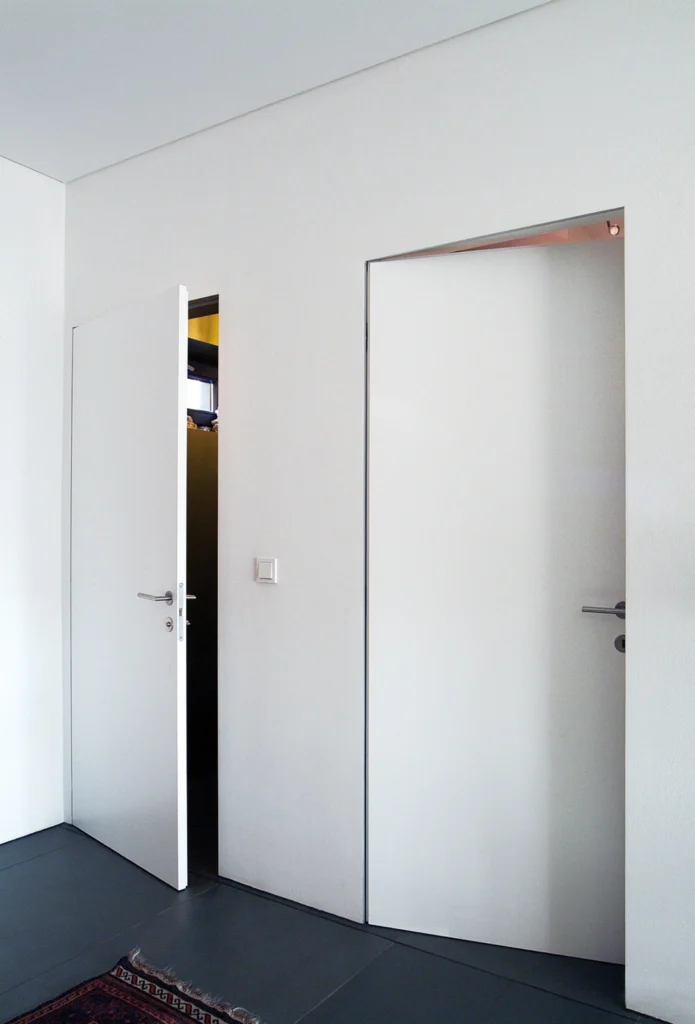 Weiße zargenlose Türen ohne sichtbaren Rahmen im modernen minimalistischen Flur